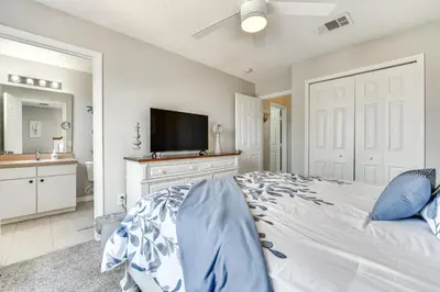 a bedroom with a large bed with a flat screen tv at Townhome 7 Mi to Disney Parks Resort Pool Access! in Kissimmee