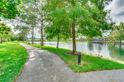 a walking path next to a river with trees at Townhome 7 Mi to Disney Parks Resort Pool Access! in Kissimmee