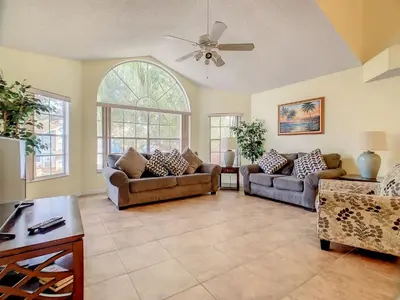 a living room with two couches and a ceiling fan at Quaint Getaway! 3 Bedroom Condo Near Disney Parks! in Kissimmee