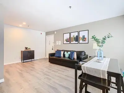 a living room with a couch and a table at Be Our Guest! 1 Bedroom Condo Near Disney Parks! in Orlando