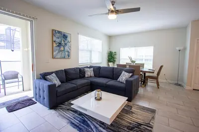 a living room with a blue couch and a table at Enchanted Orlando Getaway, 10 minutes from Disney in Kissimmee