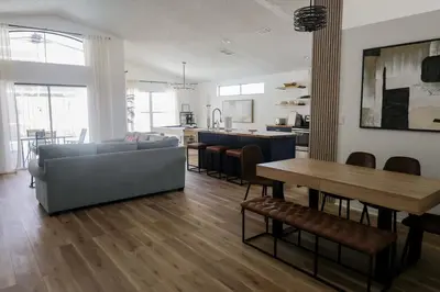 a living room with a couch and a table at Heated pool house with mini golf 10 min to Disney in Orlando
