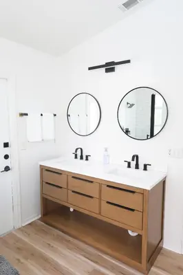a bathroom with a sink and two mirrors at Heated pool house with mini golf 10 min to Disney in Orlando