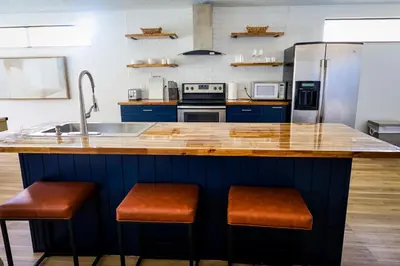 a kitchen with a sink and a counter with stools at Heated pool house with mini golf 10 min to Disney in Orlando
