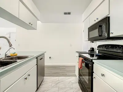 a kitchen with a sink and a stove top oven at La Casa Mediterranean! 3 Bedroom Condo Near Disney! in Kissimmee