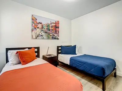a bedroom with two beds and a painting on the wall at La Casa Mediterranean! 3 Bedroom Condo Near Disney! in Kissimmee