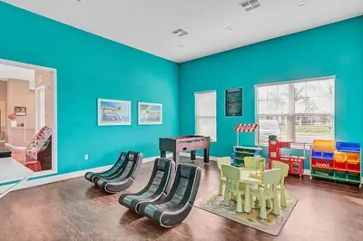 a room with blue walls and a play room with a pool table at Disney World Charm Home 4BR and 3BA! in Kissimmee