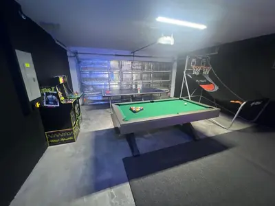 a room with a pool table in a garage at Resort Community 4 Bedroom Family Home, Pool & 15 Min Disney in Kissimmee