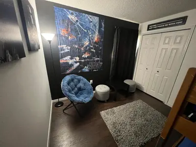 a room with a blue chair next to a door at Resort Community 4 Bedroom Family Home, Pool & 15 Min Disney in Kissimmee
