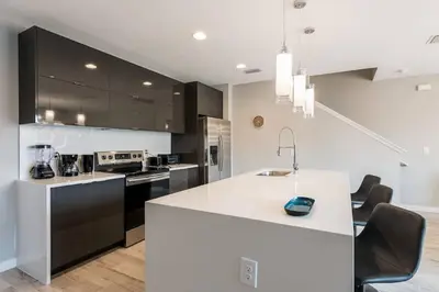 a kitchen with a white counter top and black cabinets at Family and Fun Home with Splash Pool at Le Reve 08 in Kissimmee