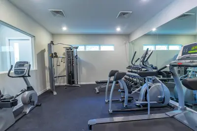 a gym with several treadmills and cardio machines at Family and Fun Home with Splash Pool at Le Reve 08 in Kissimmee