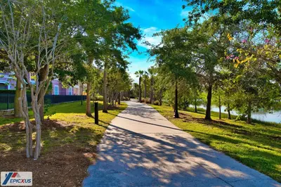 a walkway through a park with trees and grass at The Epic Chicago Vista Cay Orlando in Orlando