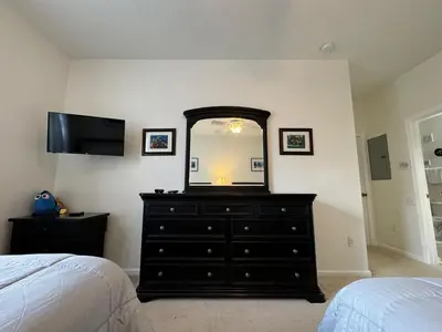 a bedroom with a dresser with a mirror and a bed at 2778 Windsor Hills 3 Bed Condo- All Included in Orlando