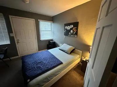 a bedroom with a bed with a blue comforter at Downtown Private Deluxe Room in Orlando