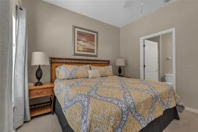 a bedroom with a bed and a lamp on a night stand at Enjoy my cozy house next to Disney in Kissimmee