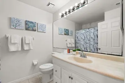 a bathroom with a sink and a toilet and a mirror at 3 Quartos + Piscina e Game Room em Orlando in Kissimmee