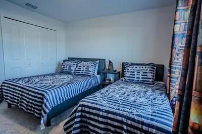two beds sitting next to each other in a bedroom at Townhouse c/Piscina Priv. Perto da Disney in Kissimmee