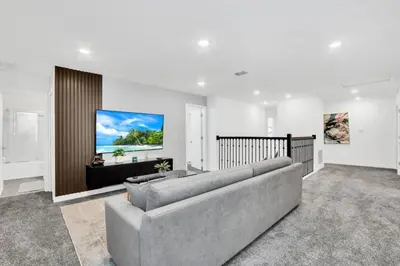 a living room with a couch and a flat screen tv at Brand New House Private Lake View 3009 Protagonist home in Kissimmee
