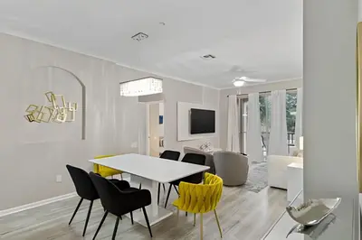 a dining room with a table and yellow chairs at Familiar 3 Quartos Perto da Disney! in Orlando