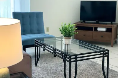 a glass coffee table in a living room with a tv at Indian Wells 3Q/2B Perto da Disney in Kissimmee