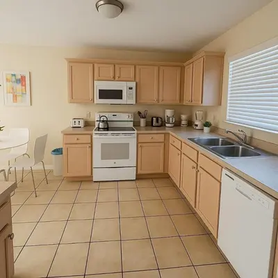 a kitchen with wooden cabinets and white appliances at Indian Wells 3Q/2B Perto da Disney in Kissimmee