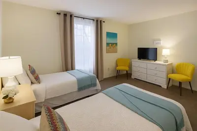 a hotel room with two beds and a television at Indian Wells 3Q/2B Perto da Disney in Kissimmee