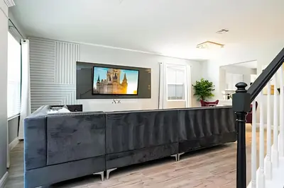 a living room with a tv on a wall at 6BD/4BA Windsor Hills | Sala de Jogos & Piscina in Orlando