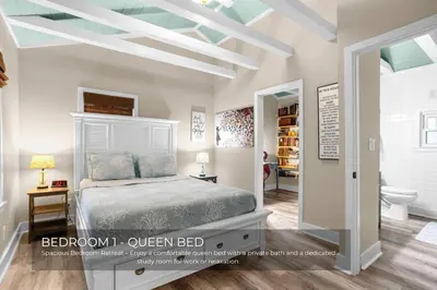 a bedroom with a bed and a bathroom at Mills Cottage in Orlando