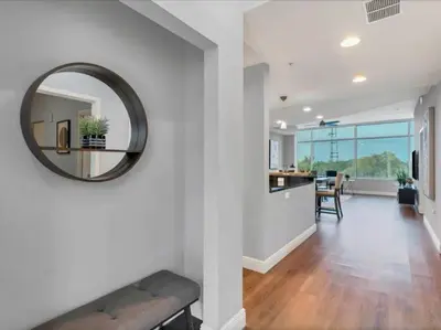 a living room with a mirror on a wall at Luxury 1260sq ft 2 Bd 2BTH in DT in Orlando