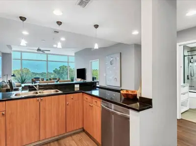 a kitchen with wooden cabinets and a stainless steel dishwasher at Luxury 1260sq ft 2 Bd 2BTH in DT in Orlando