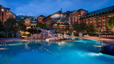 a large pool in front of a resort at night at Disney's Wilderness Lodge in Orlando