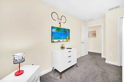 a white room with a white dresser and a desk at 4829Lullaby townhouse in Kissimmee