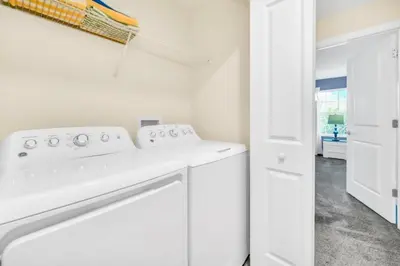 a white laundry room with a white washer and dryer at 4829Lullaby townhouse in Kissimmee
