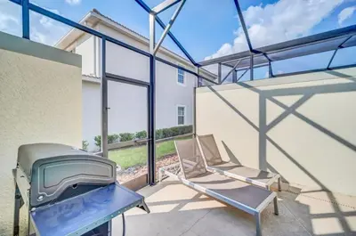 two chairs and a grill in a room with windows at 4829Lullaby townhouse in Kissimmee