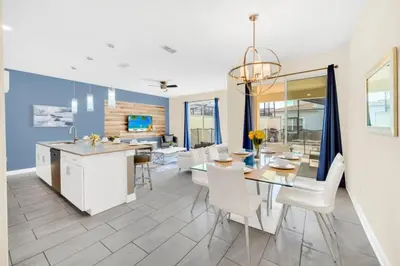 a dining room and living room with a kitchen and dining table at 4829Lullaby townhouse in Kissimmee