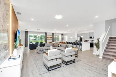 a living room with white furniture and a kitchen at Dynamic 15 Bed With Character Bedrooms Pool, Spa! villa in Kissimmee