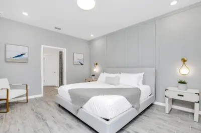 a white bedroom with a large bed and a chair at Dynamic 15 Bed With Character Bedrooms Pool, Spa! villa in Kissimmee