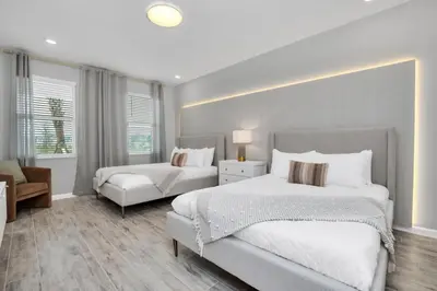 a large bedroom with two beds and a chair at Dynamic 15 Bed With Character Bedrooms Pool, Spa! villa in Kissimmee