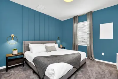 a bedroom with blue walls and a large bed at Dynamic 15 Bed With Character Bedrooms Pool, Spa! villa in Kissimmee