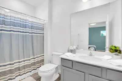 a bathroom with a toilet and a sink and a mirror at Dynamic 15 Bed With Character Bedrooms Pool, Spa! villa in Kissimmee