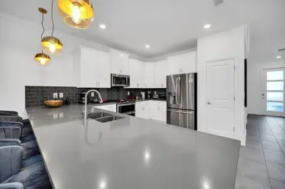 a white kitchen with a large white counter top at 2900Penolpe home in Kissimmee