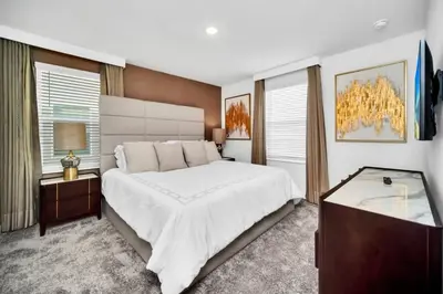 a bedroom with a large white bed and a desk at 2900Penolpe home in Kissimmee