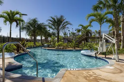 a swimming pool in a resort with palm trees at 4Q/3B Luxuosa e Moderna | Piscina Priv. in Kissimmee