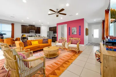 a living room with a yellow couch and chairs at 5BD Moana-Themed - Movie by the Pool - Near Disney in Orlando