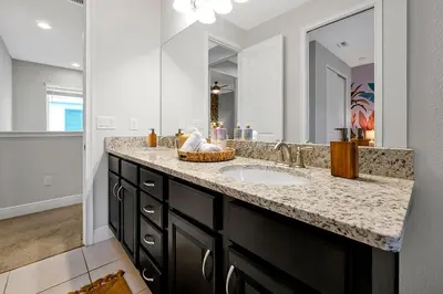 a bathroom with a sink and a large mirror at 5BD Moana-Themed - Movie by the Pool - Near Disney in Orlando