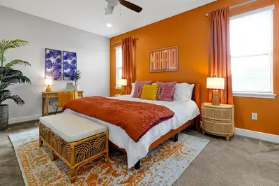 a bedroom with a large bed with orange walls at 5BD Moana-Themed - Movie by the Pool - Near Disney in Orlando