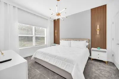 a white bedroom with a white bed and a window at Luxury 4 Bedroom Storey Lake Townhome 2444Reading townhouse in Kissimmee