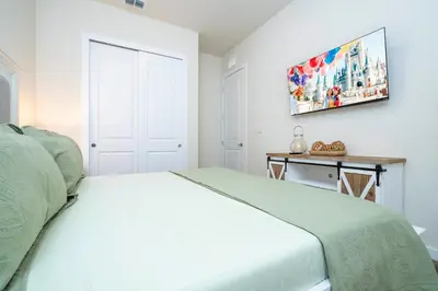 a white bedroom with a bed and a table at RCT Dreamstay in Orlando
