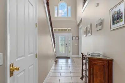 a hallway with a white door and a tile floor at Mickeys Sunrise - Phenomenal 7BR Themed Rooms Home Theater Swingset SplashPad Gas BBQ - 2 miles to Disney in Orlando