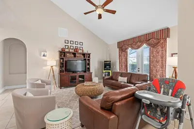 a living room with a couch and a tv at Mickeys Sunrise - Phenomenal 7BR Themed Rooms Home Theater Swingset SplashPad Gas BBQ - 2 miles to Disney in Orlando